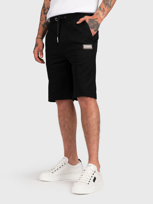 Shorts with metal logo patch